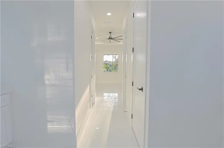 Hallway with recessed lighting, light tile patterned floors, and baseboards
