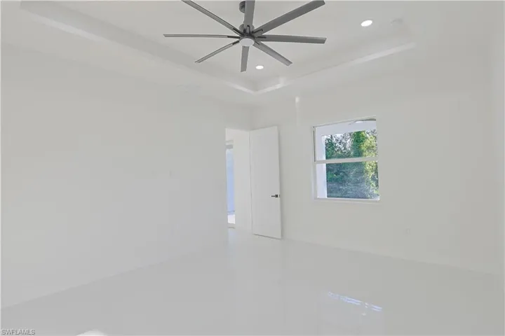 Unfurnished room featuring a raised ceiling and recessed lighting
