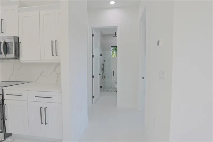 Hall featuring recessed lighting, light tile patterned floors, and baseboards