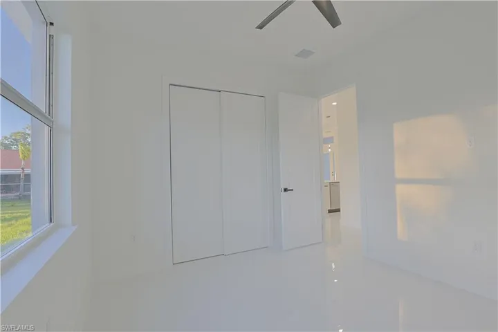 Unfurnished bedroom with tile patterned flooring, visible vents, a closet, and ceiling fan