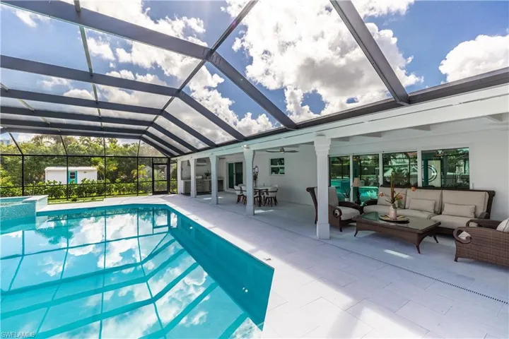 View of pool featuring outdoor lounge area, a patio, a pool with connected hot tub, ceiling fan, and a lanai