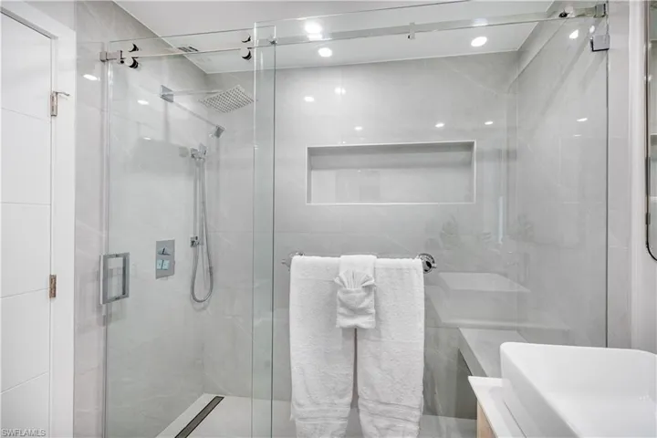 Full bath featuring a stall shower and tile walls