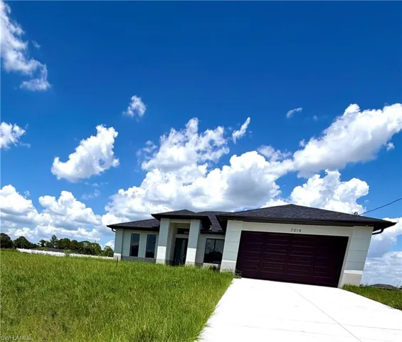 Contemporary single-story residence featuring a dark asphalt shingle roof and a two-car garage with a dark brown door