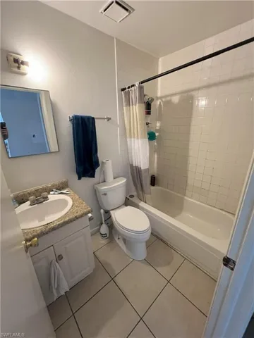 Full bathroom featuring tile patterned floors, vanity, shower / bath combo, and toilet