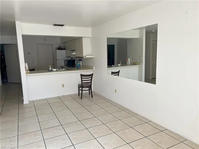 Kitchen with white fridge and light tile patterned floors
