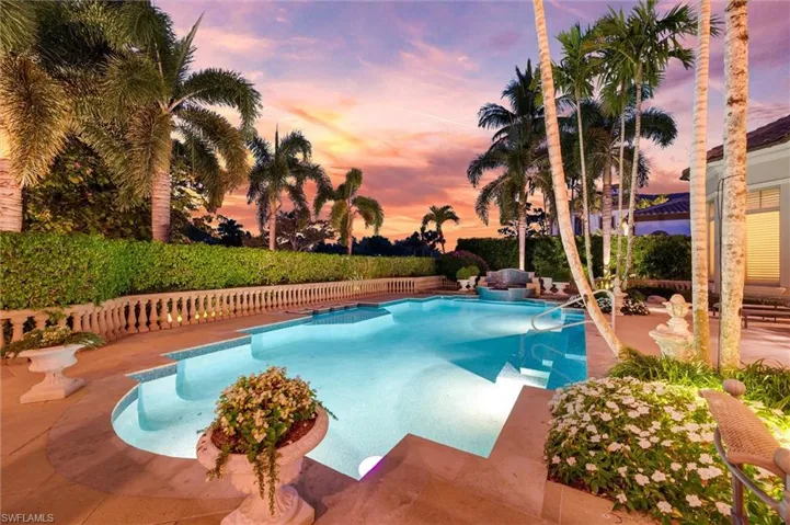 Pool at dusk with a patio area and a fenced backyard