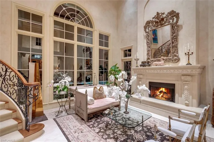 Living room featuring a high ceiling and a lit fireplace