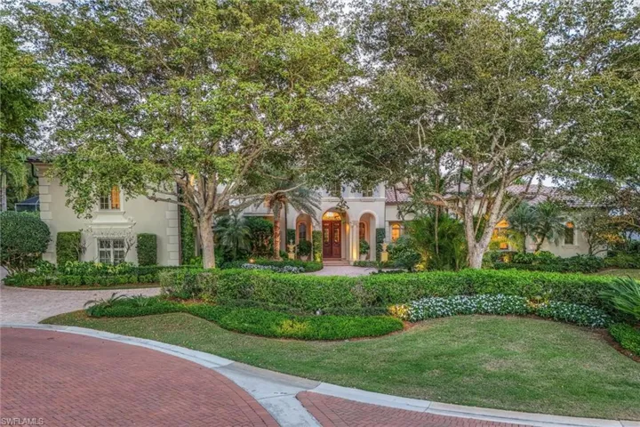 Mediterranean / spanish house with stucco siding and a front lawn