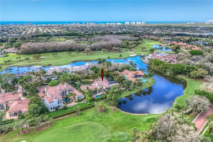 Aerial perspective of suburban area with a nearby body of water and a golf course