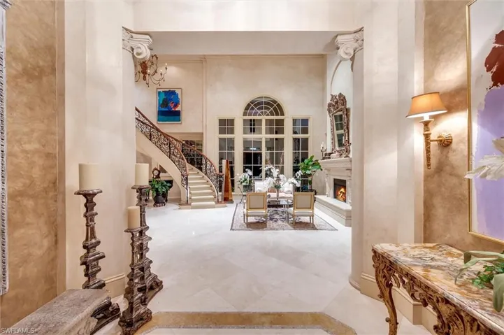 Foyer entrance featuring a high ceiling and a lit fireplace