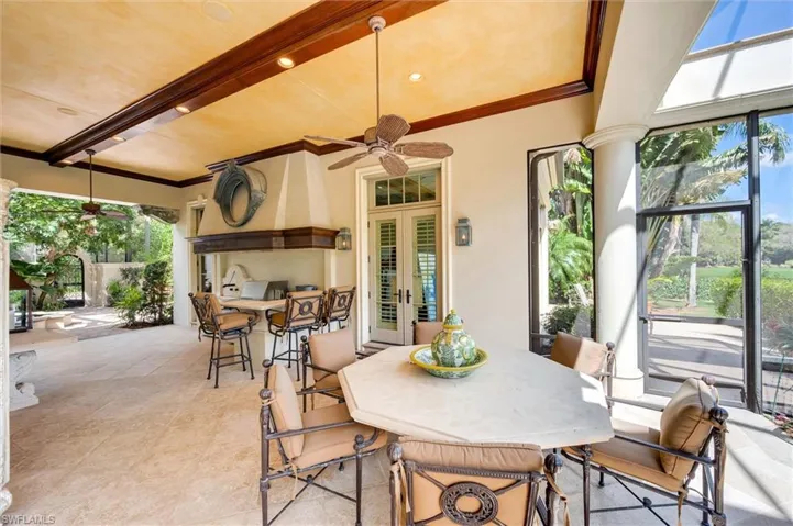 View of patio featuring a ceiling fan, french doors, an outdoor bar and dining area, and a sunroom