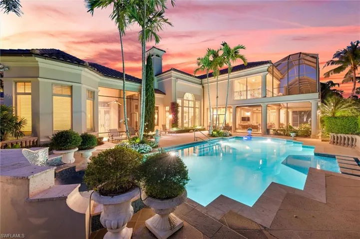 Rear view of house featuring a patio, an outdoor pool, stucco siding, and a balcony