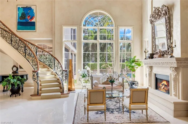 Living room with a high ceiling and a lit fireplace