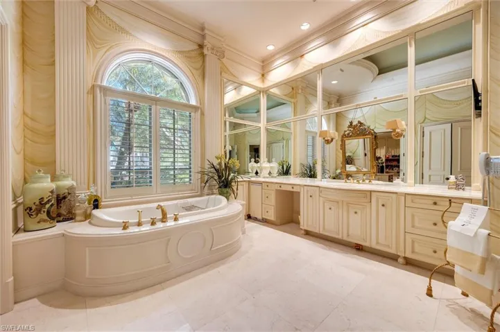 Full bathroom with a garden tub, vanity, and crown molding