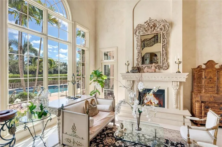 Living area featuring a warm lit fireplace and a high ceiling
