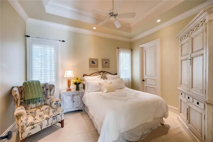 Bedroom with crown molding, ceiling fan, light colored carpet, recessed lighting, and a raised ceiling