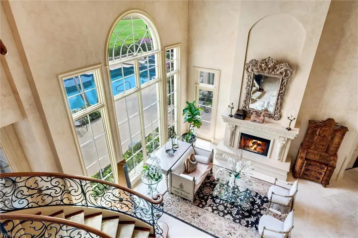 Living room with a high ceiling, a glass covered fireplace, and healthy amount of natural light