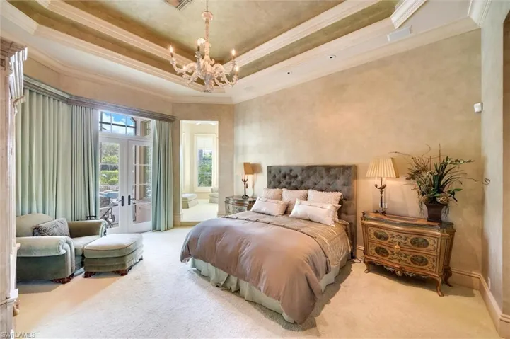 Bedroom featuring crown molding, a raised ceiling, access to exterior, light carpet, and french doors