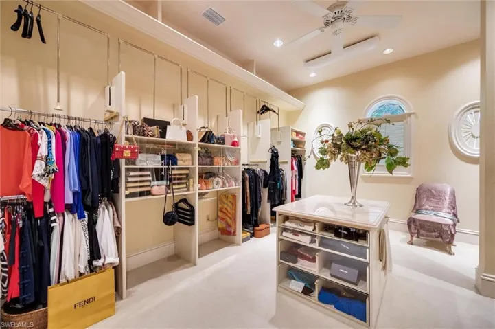 Walk in closet featuring light colored carpet and ceiling fan