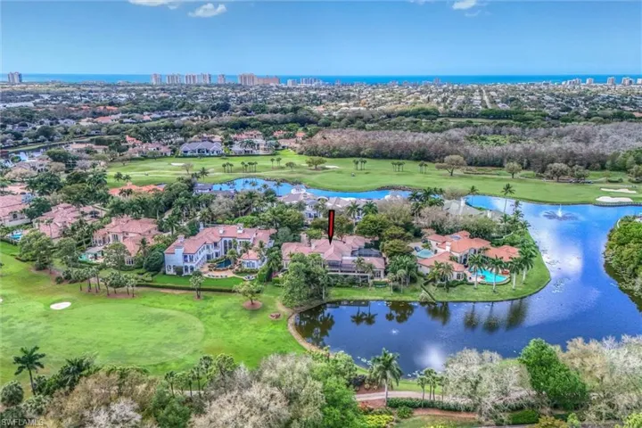 Aerial perspective of suburban area with a nearby body of water and a golf course