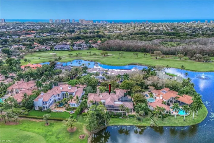 Aerial perspective of suburban area with a large body of water and a golf course