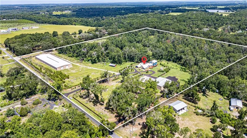 Full property aerial capturing the rare combination of luxury residence, commercial-grade buildings, and equestrian land use potential.