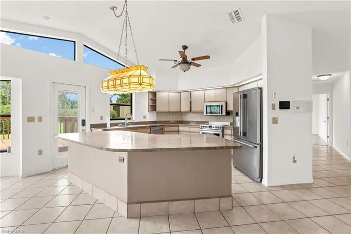 Functional kitchen with ample cabinetry and workspace, providing a practical layout with potential for modern updates or redesign to maximize value.