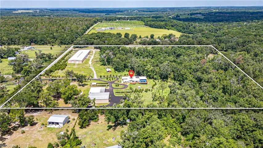 Stunning aerial perspective showcasing over 24 acres of usable land, offering privacy, expansion potential, and multiple structures including the residence and detached garage buildings. A rare opportunity with endless possibilities for residential, agricultural, or investment use.