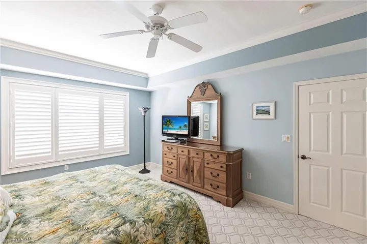 Bedroom with ornamental molding and a ceiling fan