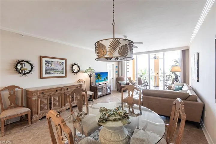 Dining space featuring expansive windows, ornamental molding, light tile patterned flooring, and ceiling fan