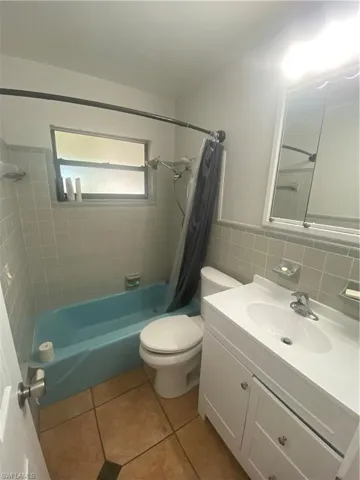 Bathroom featuring a blue bathtub, white vanity with integrated sink, and a mirrored medicine cabinet
