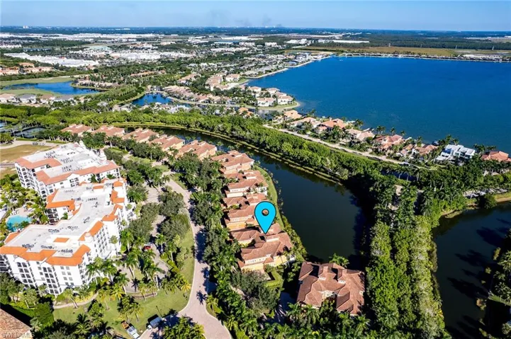 Aerial view of property's location featuring a nearby body of water and nearby suburban area