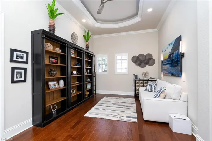 Sitting room featuring a tray ceiling, ornamental molding, dark wood-style floors, ceiling fan, and recessed lighting