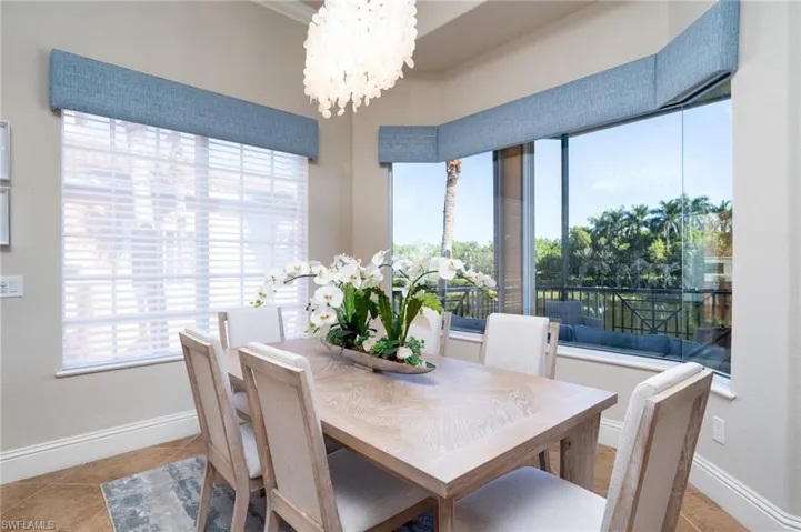 Dining space with light tile patterned floors and a chandelier