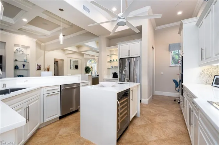 Kitchen with coffered ceiling, pendant lighting, beam ceiling, a center island, and ornamental molding