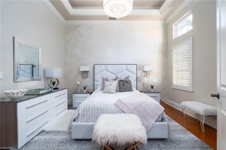 Bedroom with wood finished floors and crown molding