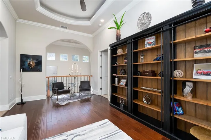 Sitting room with a chandelier, dark wood-style floors, a tray ceiling, crown molding, and recessed lighting