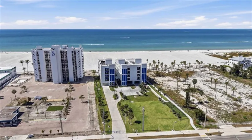 Drone / aerial view of unending shoreline and apartment complex