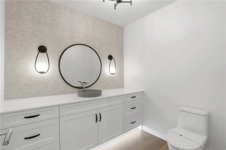 Half bathroom featuring vanity and light wood-type flooring