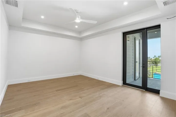 Spare room with a raised ceiling, a ceiling fan, light wood-style flooring, and recessed lighting