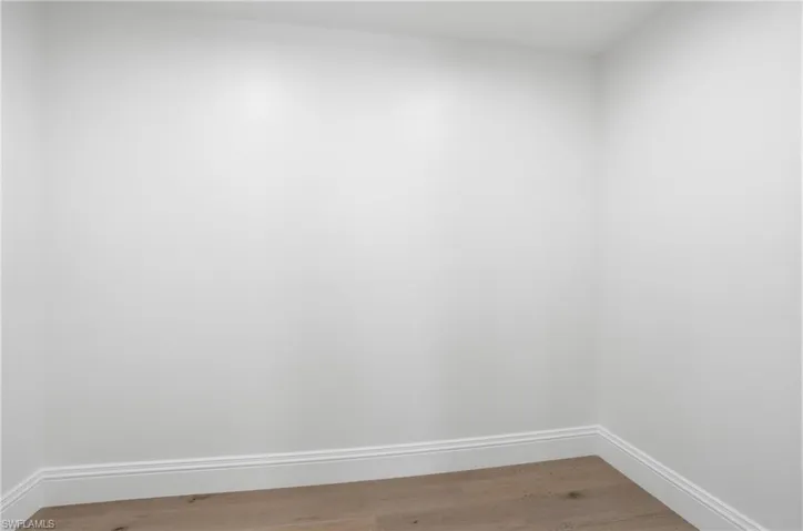 Spare room with baseboards and light wood-type flooring