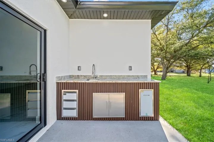 View of patio featuring an outdoor kitchen and a sink