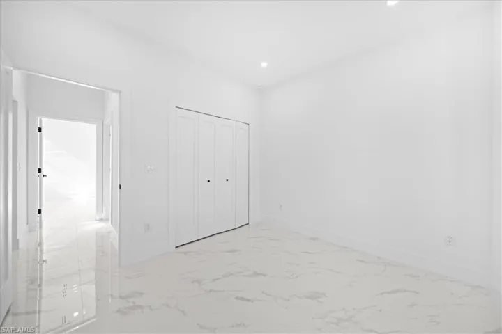 Unfurnished bedroom with light marble finish floors, a closet, and recessed lighting