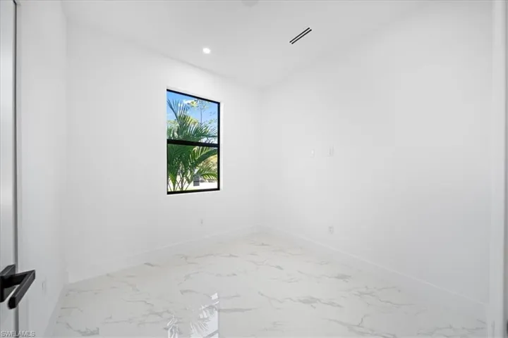 Unfurnished room with light marble finish floors and recessed lighting