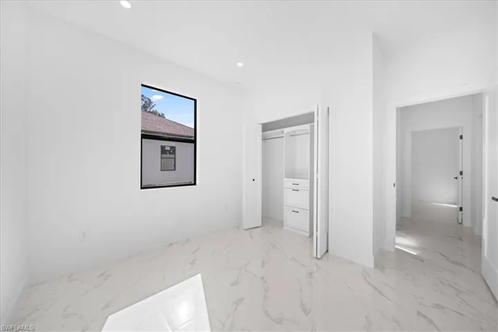 Unfurnished bedroom featuring light marble finish floors, recessed lighting, and a closet