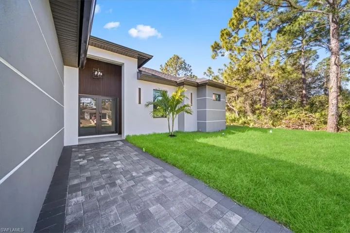 Property entrance featuring a yard, stucco siding, and french doors