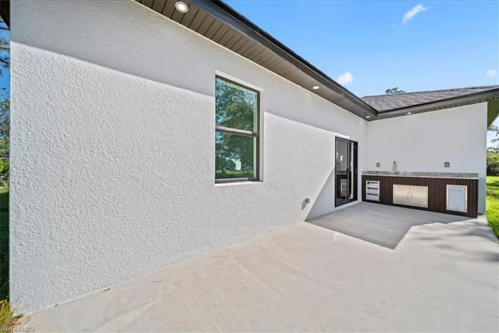 View of home's exterior with stucco siding and a patio