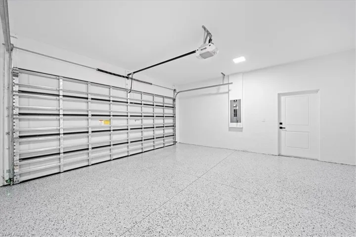 Garage with electric panel and a garage door opener
