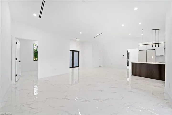 Unfurnished living room featuring recessed lighting and lofted ceiling