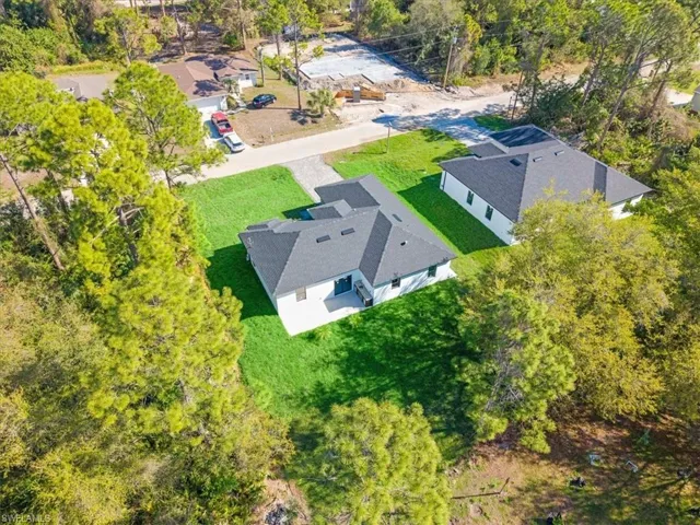 View of subject property with a tree filled landscape